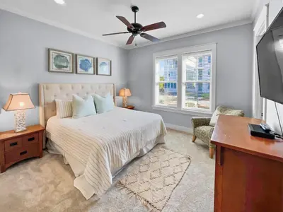 a bedroom with a bed and a flat screen tv at Pompano Palace l Bike or Walk to Rosemary l Gulf Views l Community Pool in Rosemary Beach