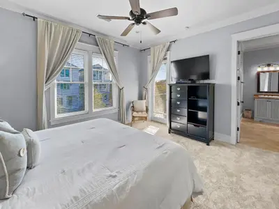 a bedroom with a bed and a flat screen tv at Pompano Palace l Bike or Walk to Rosemary l Gulf Views l Community Pool in Rosemary Beach