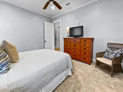 a bedroom with a bed and a tv on a dresser at Pompano Palace l Bike or Walk to Rosemary l Gulf Views l Community Pool in Rosemary Beach