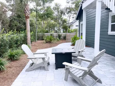 two chairs and a table on a patio at Pinewood l Inlet Beach l Dog Friendly in Inlet Beach