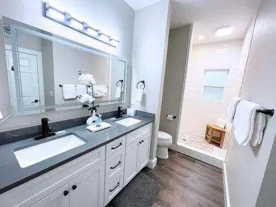 a bathroom with a sink and a mirror and a toilet at Pinewood l Inlet Beach l Dog Friendly in Inlet Beach