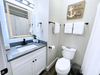 a bathroom with a toilet and a sink and a mirror at Pinewood l Inlet Beach l Dog Friendly in Inlet Beach