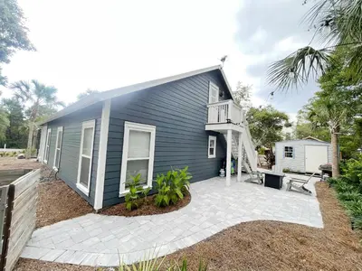 a blue house with a patio in front of it at Pinewood l Inlet Beach l Dog Friendly in Inlet Beach
