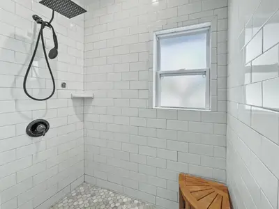 a white tiled shower with a window in a bathroom at Pinewood l Inlet Beach l Dog Friendly in Inlet Beach