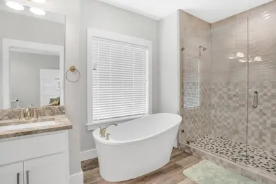 a white bathroom with a tub and a shower at Pura Vida l 5 Bedroom l Private Pool l Walk to Beach l Panama City Beach in Panama City Beach