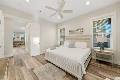 a white bedroom with a bed and a ceiling fan at Pura Vida l 5 Bedroom l Private Pool l Walk to Beach l Panama City Beach in Panama City Beach