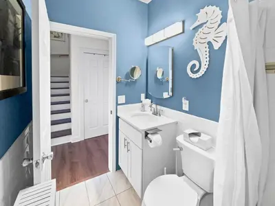 a bathroom with a white toilet and a blue wall at Sand Piper l 4 Minute Walk to the Beach l Inlet Beach in Inlet Beach