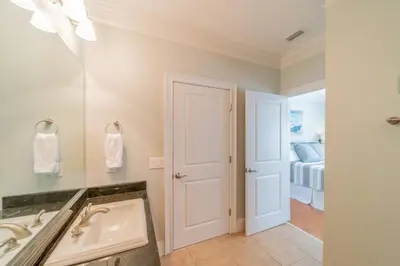 a bathroom with a sink and a mirror and a bed at Sand Seair l Private Heated Pool l Bikes and Golf Cart included in Inlet Beach