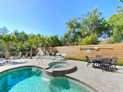 a swimming pool with chairs and a table in a yard at Sand Seair l Private Heated Pool l Bikes and Golf Cart included in Inlet Beach