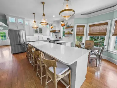 a kitchen with a large white counter and chairs at Sand Seair l Private Heated Pool l Bikes and Golf Cart included in Inlet Beach