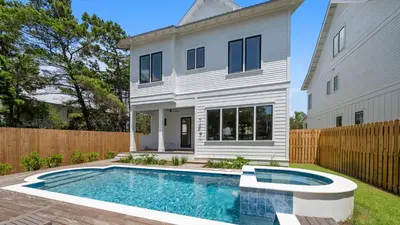 a white house with a swimming pool in the yard at Sand Wand l 5 Beds l 5 and half Bath l Private Pool l Walk to Beach l Seagrove Beach 30A in Santa Rosa Beach