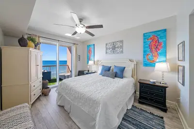 a bedroom with a bed with a ceiling fan at Sea Horsey Retreat l Community Heated Pool l Amazing Ocean Views l Beachfront Condo in Panama City Beach