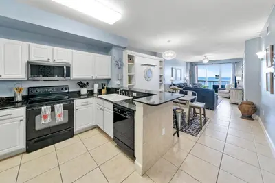 a kitchen with white cabinets and an open floor plan at Sea Horsey Retreat l Community Heated Pool l Amazing Ocean Views l Beachfront Condo in Panama City Beach