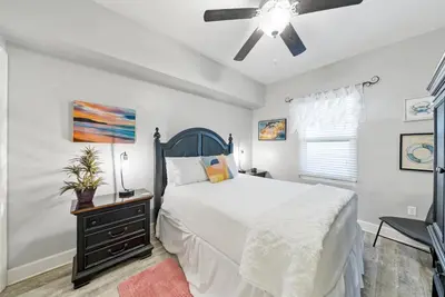 a bedroom with a bed and a ceiling fan at Sea Horsey Retreat l Community Heated Pool l Amazing Ocean Views l Beachfront Condo in Panama City Beach