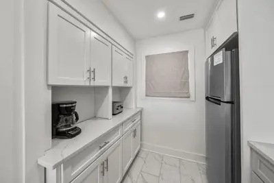 a kitchen with white cabinets and a refrigerator at Seacrest 6 l Beachfront l Bike to Alys and Rosemary Beach in Seacrest
