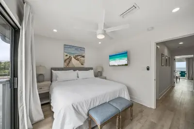a white bedroom with a bed and a window at Seacrest 6 l Beachfront l Bike to Alys and Rosemary Beach in Seacrest