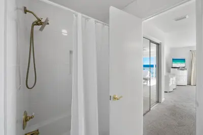 a white bathroom with a shower with a glass door at Seacrest 8 l Beachfront l Bike to Alys and Rosemary Beach in Seacrest
