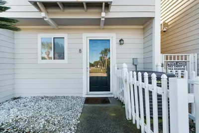 a white house with a door and a fence at Seacrest 8 l Beachfront l Bike to Alys and Rosemary Beach in Seacrest