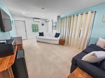 a living room with a couch and a tv at Shoreline Breeze l Steps to the Beach l Beautiful views from 2nd and 3rd balconies in Inlet Beach
