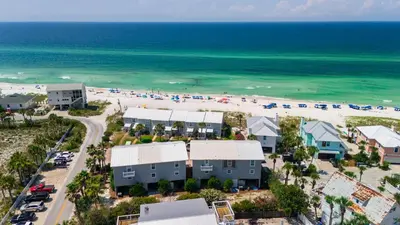 an aerial view of a beach with houses and cars at Shoreline Breeze l Steps to the Beach l Beautiful views from 2nd and 3rd balconies in Inlet Beach