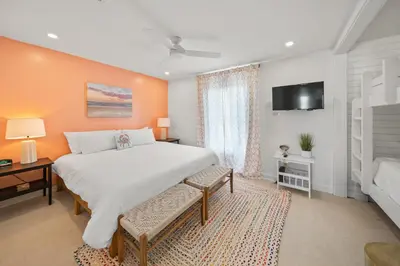 a bedroom with a large white bed and a tv at Shoreline Breeze l Steps to the Beach l Beautiful views from 2nd and 3rd balconies in Inlet Beach