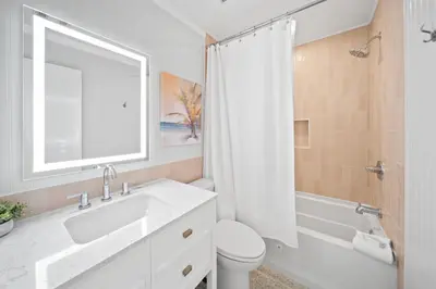 a bathroom with a sink and a toilet and a window at Shoreline Breeze l Steps to the Beach l Beautiful views from 2nd and 3rd balconies in Inlet Beach