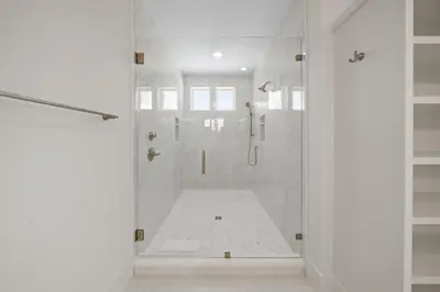 a white bathroom with a shower with a glass door at Shore Thing l Private Pool l Walk to the beach l Bike to Seaside l Brand New Construction and Decor in Santa Rosa Beach