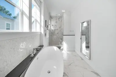 a white bathroom with a tub and a window at Someday Came l 4 Bikes and Beach Towels l Community Pool in Inlet Beach