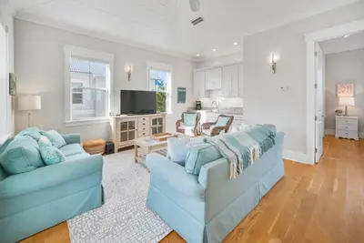 a living room with two blue couches and a television at Someday Came l 4 Bikes and Beach Towels l Community Pool in Inlet Beach