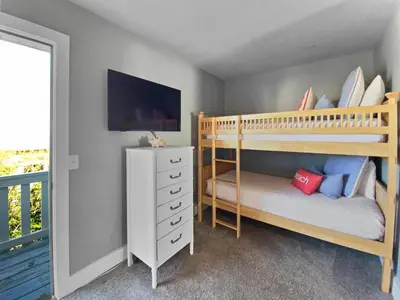 a bedroom with two bunk beds and a television at Shoreline Townhomes 10 l Steps to the Beach l Beautiful views from 2nd and 3rd balconies in Inlet Beach