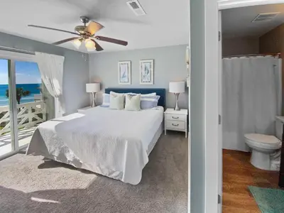 a bedroom with a bed and a balcony with the ocean at Shoreline Townhomes 10 l Steps to the Beach l Beautiful views from 2nd and 3rd balconies in Inlet Beach