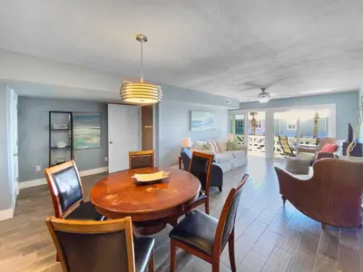 a dining room and living room with a table and chairs at Shoreline Townhomes 10 l Steps to the Beach l Beautiful views from 2nd and 3rd balconies in Inlet Beach