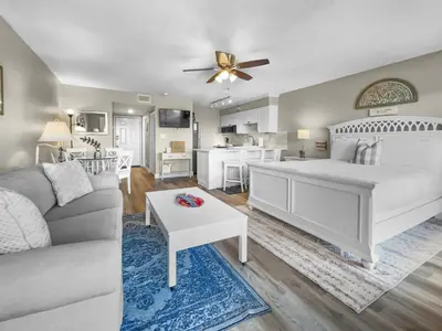 a bedroom with a bed and a living room at SummerSalt l Ocean Views l Heated Community Pool l Dog Friendly in Seagrove Beach