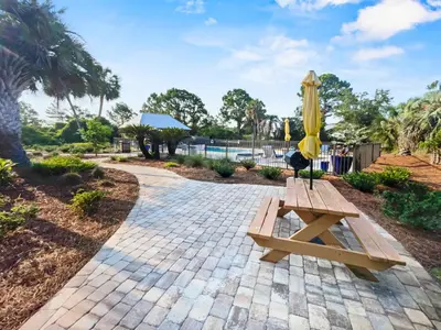 a picnic table with an umbrella on a brick path at SummerSalt l Ocean Views l Heated Community Pool l Dog Friendly in Seagrove Beach