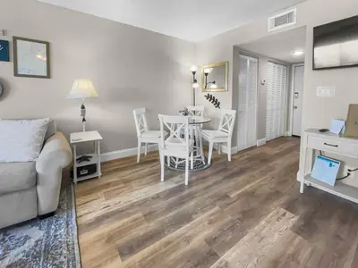 a living room with a table and chairs and a couch at SummerSalt l Ocean Views l Heated Community Pool l Dog Friendly in Seagrove Beach