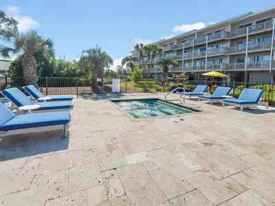 a swimming pool with lounge chairs and a building at SummerSalt l Ocean Views l Heated Community Pool l Dog Friendly in Seagrove Beach