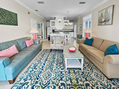 a living room with a couch and a table at SummerTowne 1 At Pier Park l Amazing Ocean Views l Dog Friendly l Community Pool in Panama City Beach