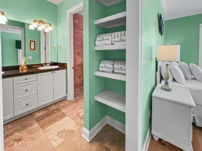 a bedroom with green walls and a bed and a mirror at Surfer Dog l Beachfront Pool l Includes Beach Chairs and Bikes in Inlet Beach
