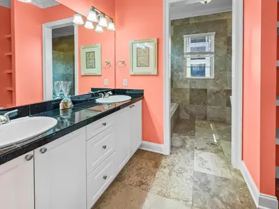 a bathroom with two sinks and orange walls at Surfer Dog l Beachfront Pool l Includes Beach Chairs and Bikes in Inlet Beach