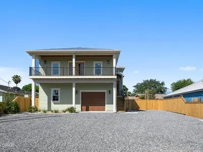 a house with a driveway with a garage at PCB Luxe 4BR, Heated Pool, 3 Blks to Beach in Panama City Beach