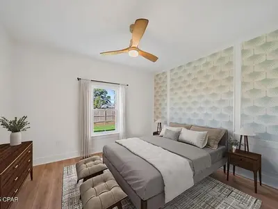 a bedroom with a bed and a ceiling fan at PCB Luxe 4BR, Heated Pool, 3 Blks to Beach in Panama City Beach