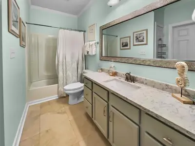 a bathroom with a sink and a toilet and a mirror at The Flipside 30A l Heated Community Pool and Hot Tub l Steps to Rosemary Beach in Rosemary Beach