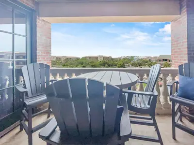 a table and chairs on a balcony with a view at The Flipside 30A l Heated Community Pool and Hot Tub l Steps to Rosemary Beach in Rosemary Beach