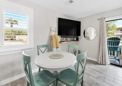 a white dining room with a white table and green chairs at One Bedroom at Beachwood Villas on 30a in Seagrove, Florida in Santa Rosa Beach