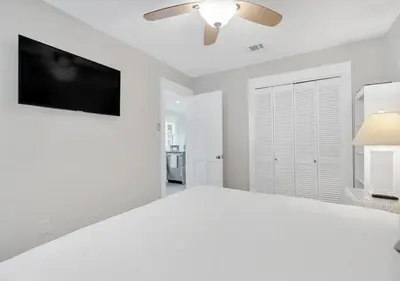 a white bedroom with a ceiling fan and a tv at One Bedroom at Beachwood Villas on 30a in Seagrove, Florida in Santa Rosa Beach
