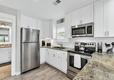 a kitchen with white cabinets and a stainless steel refrigerator at One Bedroom at Beachwood Villas on 30a in Seagrove, Florida in Santa Rosa Beach
