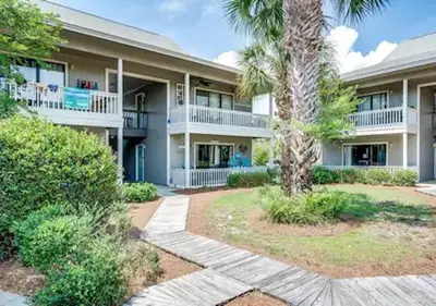 an exterior view of a building with a palm tree at One Bedroom at Beachwood Villas on 30a in Seagrove, Florida in Santa Rosa Beach