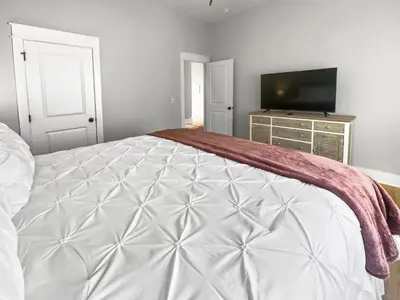 a bedroom with a large bed and a flat screen tv at The Way of Water l Community Pool l 2 Bikes included in Inlet Beach