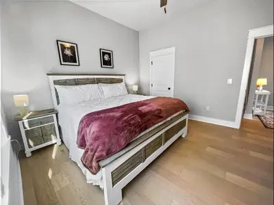 a bedroom with a large bed and a wooden floor at The Way of Water l Community Pool l 2 Bikes included in Inlet Beach