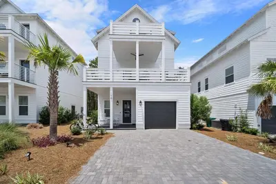 a white house with a balcony and a driveway at The Way of Water l Community Pool l 2 Bikes included in Inlet Beach